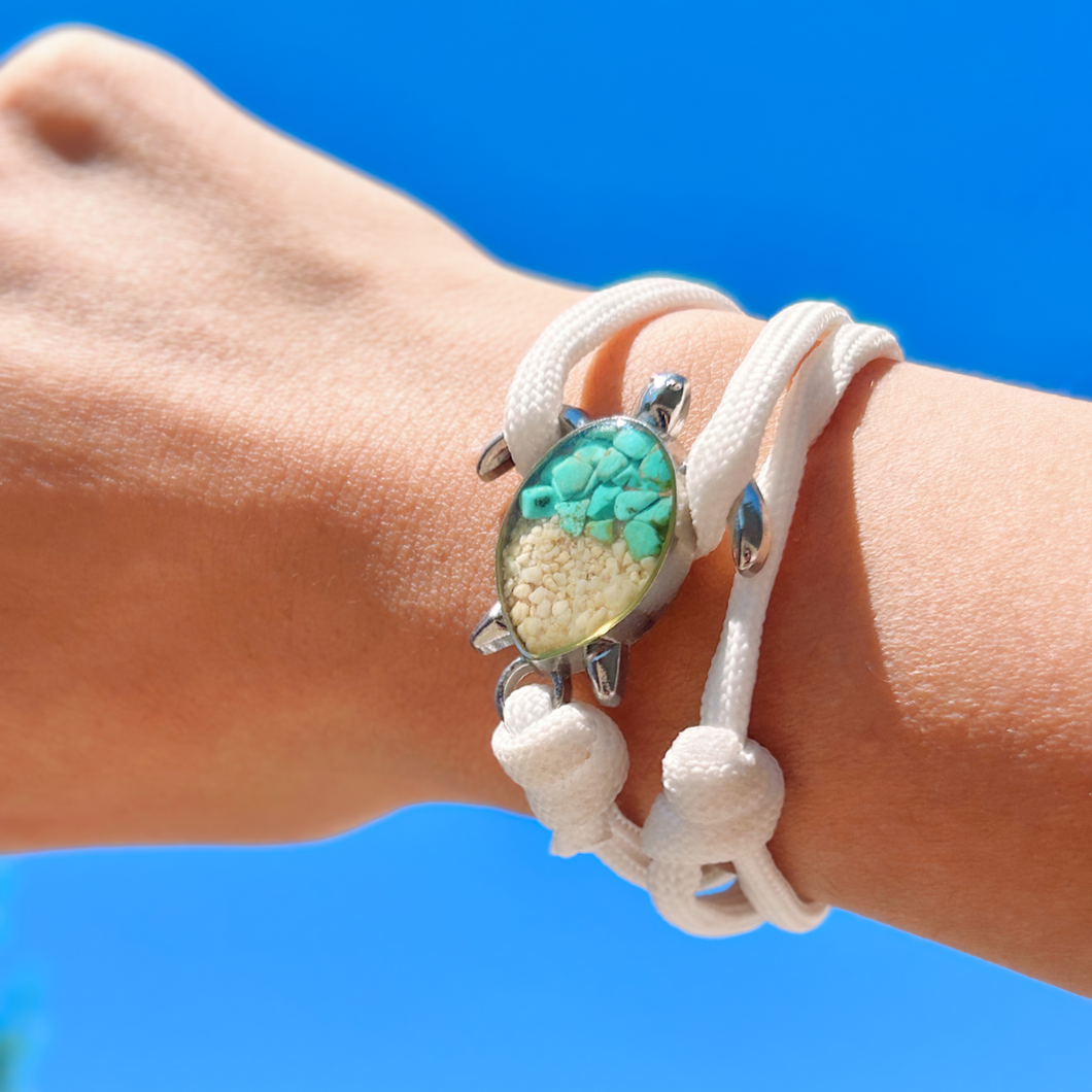 White Rope Sand Sea Turtle Bracelet in Teal Turquoise is displayed by being worn around a woman's wrist.