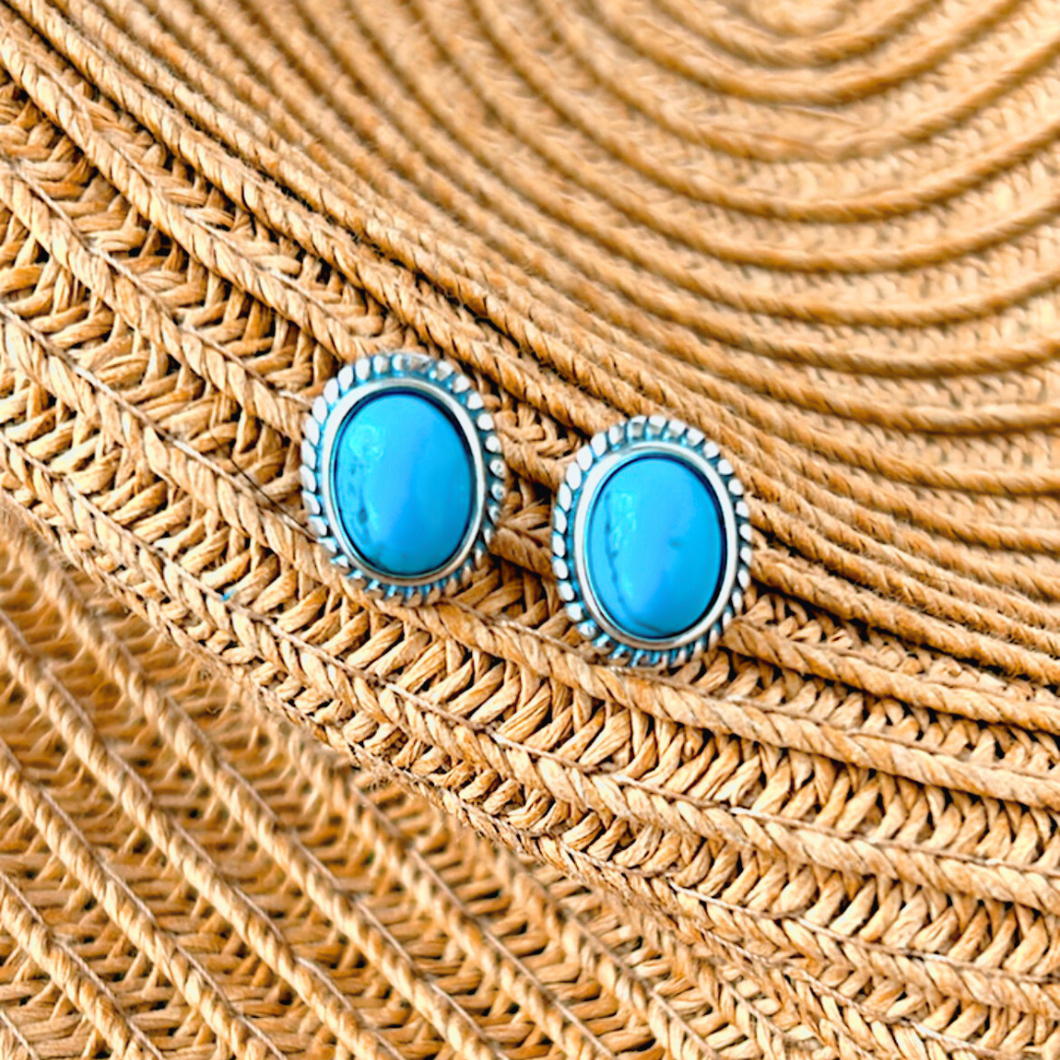 .925 Silver Turquoise Oval Studs displayed on a part of a straw hat.