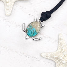 Load image into Gallery viewer, Black Rope Sand Sea Turtle Bracelet in Teal Turquoise is displayed on a white wooden surface.
