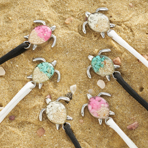 Black and White Rope Sand Sea Turtle Bracelets are all placed on a sandy surface.