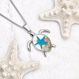 Deep in the Ocean Sea Turtle Necklace displayed on a white wooden surface.