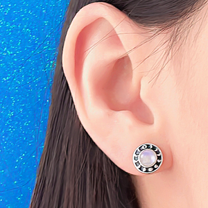 Moonstone Moon Phase Stud displayed closely by being worn on a woman's ear.