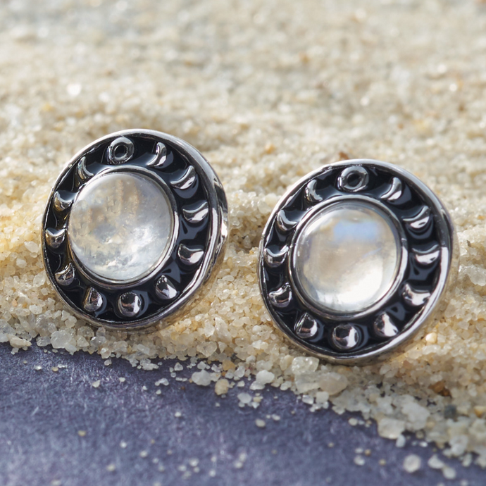 Moonstone Moon Phase Studs placed on sandy grains.