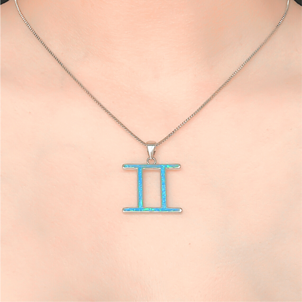 Opal Gemini Necklace displayed closely by being worn around a woman's neck.