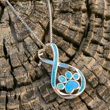 Load image into Gallery viewer, Opal Infinity Love Paw Necklace displayed on a rustic dried wooden log surface.