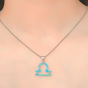 Opal Libra Necklace displayed closely by being worn around a woman's neck.