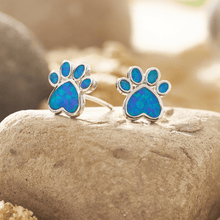 Load image into Gallery viewer, Opal Love Paw Studs are displayed by being placed on top of a rock against a blurred background.