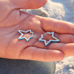 Opal Star Hoop Earrings are displayed by being placed on the palm of a hand.