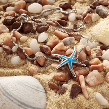 Load image into Gallery viewer, The Opal Starfish Bracelet is displayed on top of a sandy pebble-covered surface.