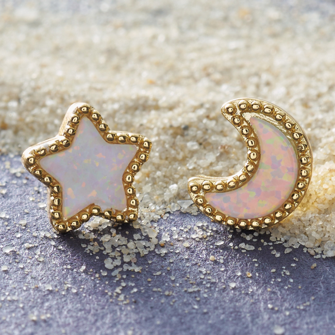 Opal Starry Night Studs placed on sandy grains.