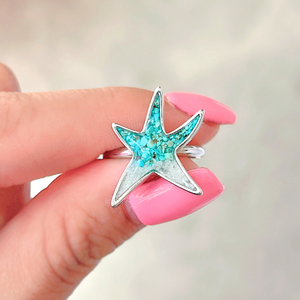 SSand Sea Star Ring elegantly showcased by a woman's hand.