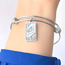 Load image into Gallery viewer, The Moon Tarot Card Bracelet displayed by being worn around a woman&#39;s wrist.