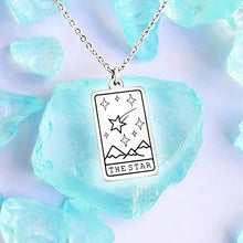 Load image into Gallery viewer, The Star Tarot Card Necklace displayed on a blue crystal surrounded by other blue crystals.