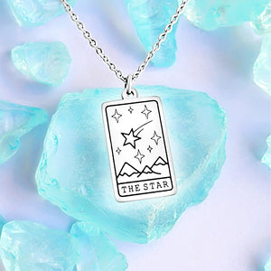 The Star Tarot Card Necklace displayed on a blue crystal surrounded by other blue crystals.