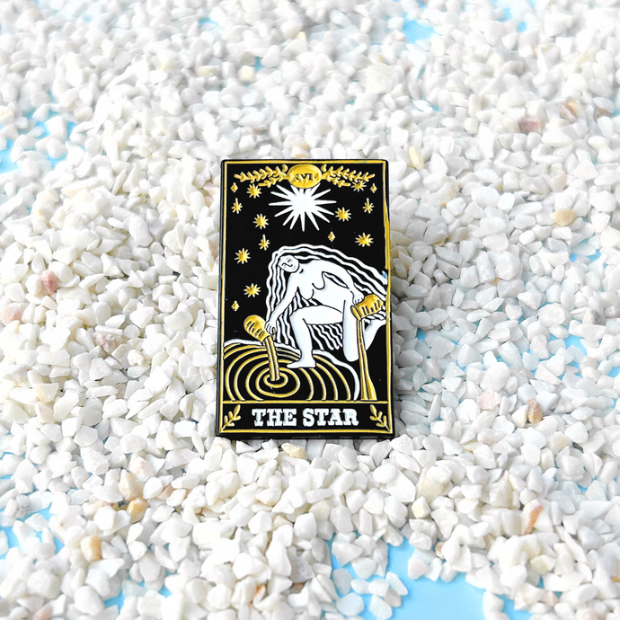 The Star Tarot Card Pin displayed on sandy terrain.