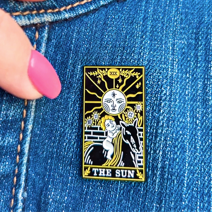 The Sun Tarot Card Pin displayed on denim cloth.