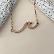 Load image into Gallery viewer, The Wave Necklace is displayed on a smooth, dirty white surface.