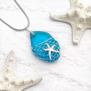 What a Catch Necklace in Ocean Blue displayed on a white wooden surface.