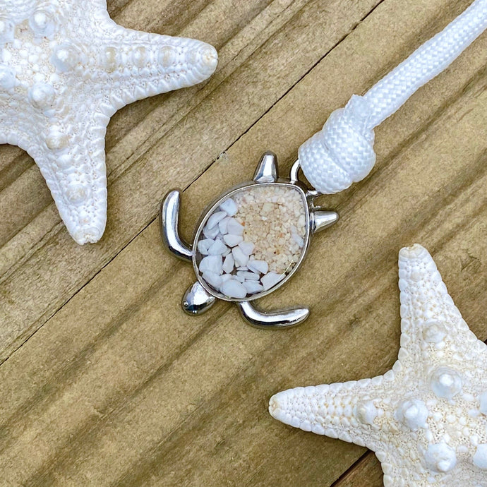 White Rope Sand Sea Turtle Bracelet in White Turquoise is displayed on a wooden surface.