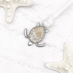 White Rope Sand Sea Turtle Bracelet in White Turquoise is displayed on a white wooden surface.