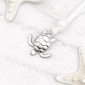 White Rope Sea Turtle Bracelet displayed on a white wooden surface.