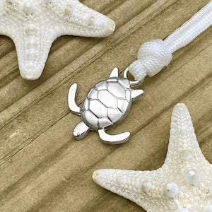 White Rope Sea Turtle Bracelet displayed on a wooden surface.